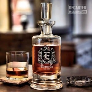 Personalized Kensington lead-free crystal whiskey decanter with custom engraved Grand heraldic crest design, shown with matching whiskey glass.