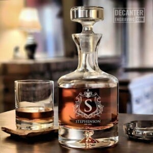 Personalized Taylor lead-free crystal whiskey decanter with custom engraved Gild royal crest monogram design, shown with matching whiskey glass.