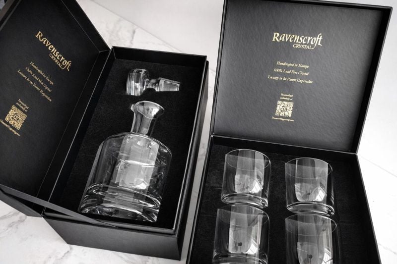 Two-piece luxury gift box set for custom engraved crystal whiskey decanters and four glasses, designed for executive-level gifting with gold-foil stamping and silk-lined custom foam inserts.